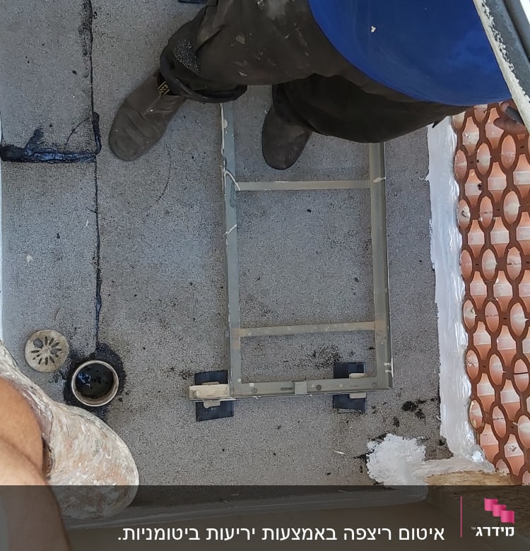 אדם עובד על איטום גג עם חומרים וכלים